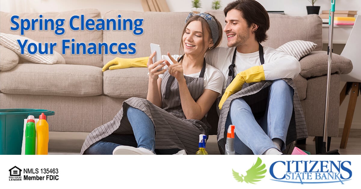 Young couple spring cleaning their home and reviewing their finances